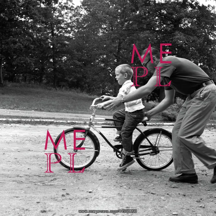 : Father giving son on bike a push teaching him : Father giving son on bike a push teaching him