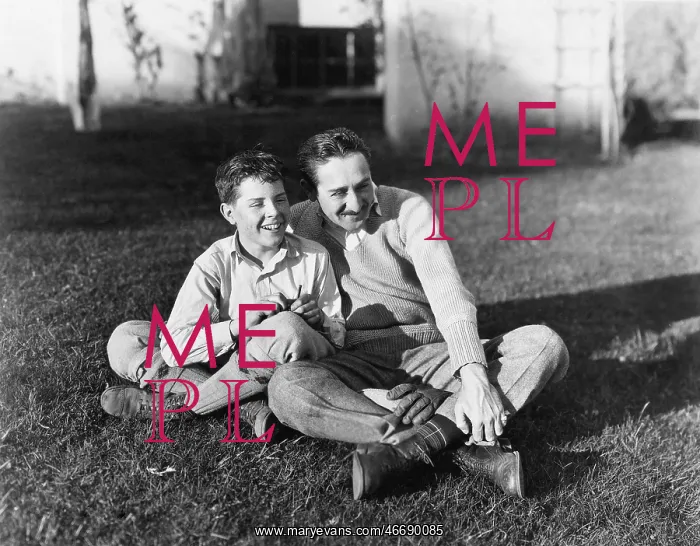 : Father and son sitting together on the grass in : Father and son sitting together on the grass in