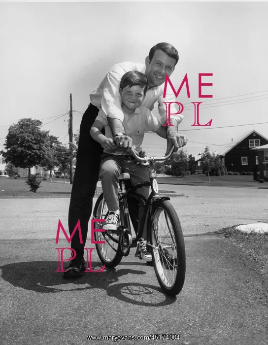 : Father stopping to pose with son while teaching him to ride : Father stopping to pose with son while teaching him to ride