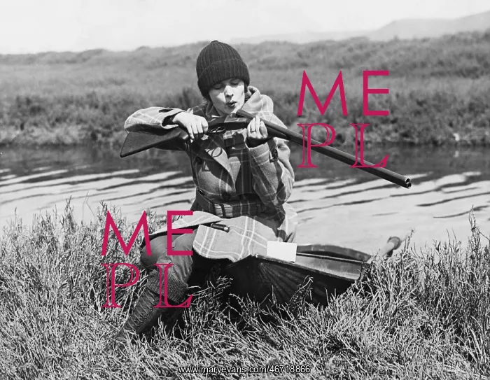 : Female hunter with gun near river : Female hunter with gun near river