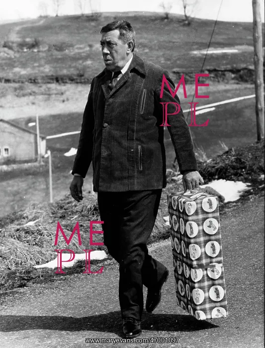 : Fernandel, French comedian, carrying a present : Fernandel, French comedian, carrying a present