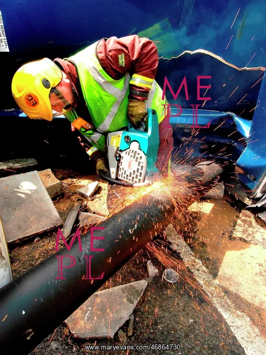 : Firefighter cutting through pipe after road traffic accident : Firefighter cutting through pipe after road traffic accident