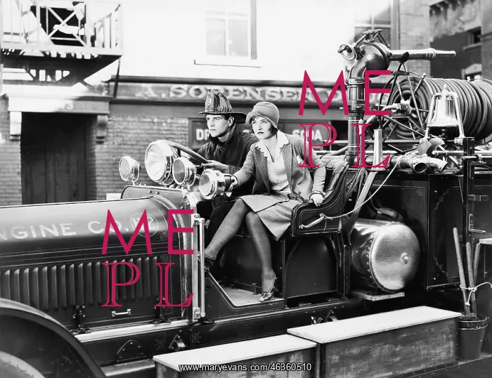 : Firefighter driving a fire engine and a young woman : Firefighter driving a fire engine and a young woman