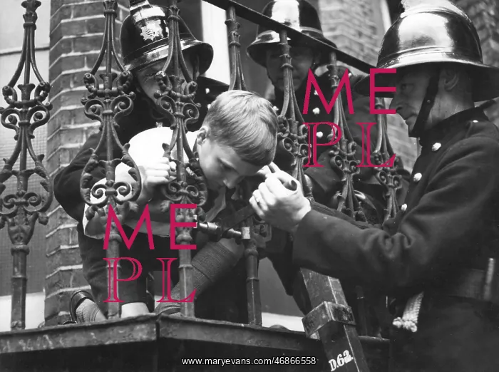 : Firefighter using railing expander to release boy : Firefighter using railing expander to release boy