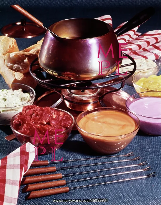 : Fondue Pot on Table with Bowls of Assorted Toppings : Fondue Pot on Table with Bowls of Assorted Toppings
