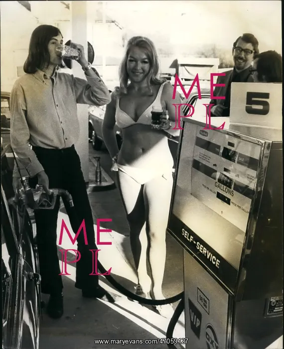 : Gas - Oil. Mar. 03, 1972 - A kiss or beer for motorists buying petrol at new garage at St : Gas - Oil. Mar. 03, 1972 - A kiss or beer for motorists buying petrol at new garage at St