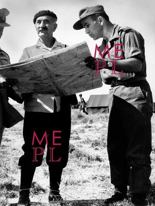 : General Georgios Grivas looking over a map with soldiers : General Georgios Grivas looking over a map with soldiers
