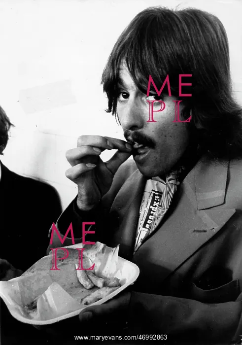 : George Harrison of The Beatles pop group eating chips : George Harrison of The Beatles pop group eating chips
