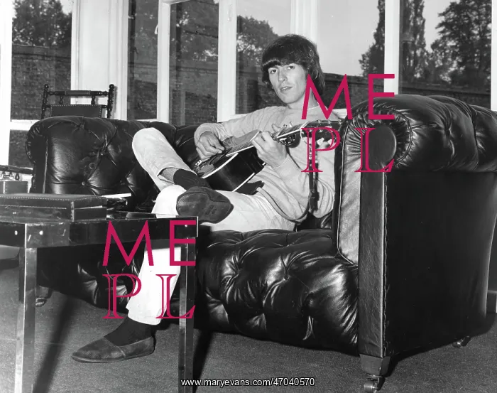 : George Harrison of The Beatles relaxes with guitar : George Harrison of The Beatles relaxes with guitar
