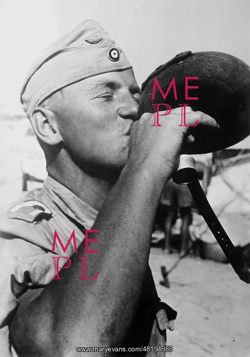 : A German soldier drinking from a water bottle, 1942 : A German soldier drinking from a water bottle, 1942