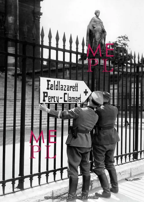 : German soldiers mount a signpost to the gate : German soldiers mount a signpost to the gate