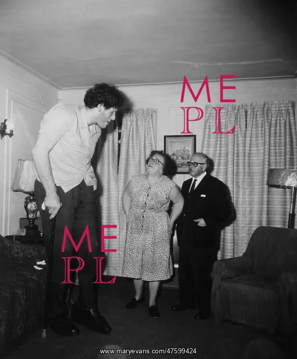 : Gigantism. Giant, with his parents in their living room in 1970 : Gigantism. Giant, with his parents in their living room in 1970