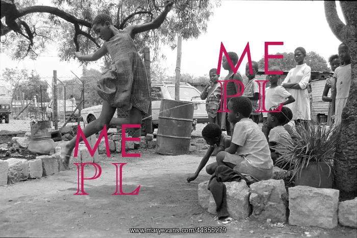 : Girl leaping over string, a game in Oukasie. The people : Girl leaping over string, a game in Oukasie. The people