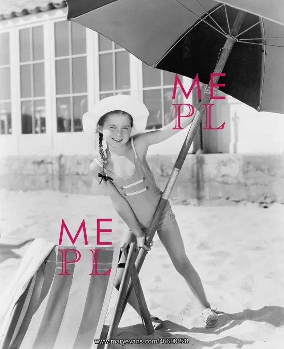 : Girl placing a large umbrella into the sand : Girl placing a large umbrella into the sand