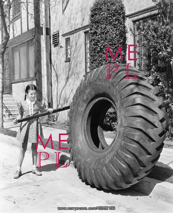 : Girl playing with a huge tire and stick : Girl playing with a huge tire and stick