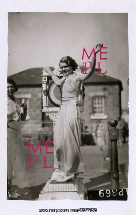 : Girl testing her weight on a seafront weighing machine : Girl testing her weight on a seafront weighing machine