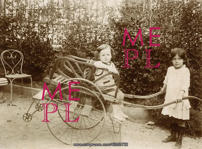 : Two girls playing with a push cart : Two girls playing with a push cart