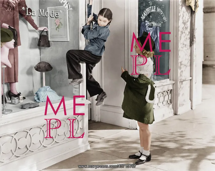 : Two girls on the street with one climbing on a display : Two girls on the street with one climbing on a display