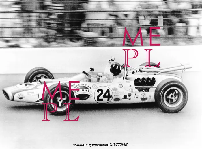 : Graham Hill, waves as his car streaks toward the : Graham Hill, waves as his car streaks toward the