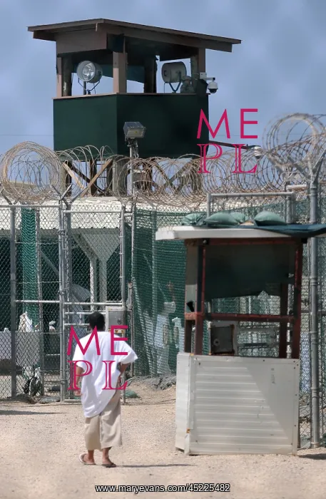 : Under the guard tower a detainee walks in ? : Under the guard tower a detainee walks in ?