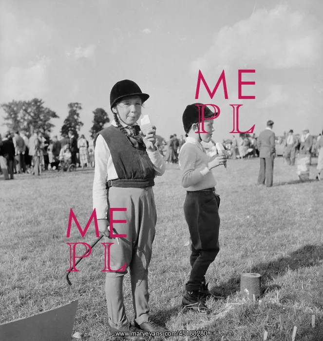 : Gymkhana. Two children in riding gear eating ice creams at a gymkhana : Gymkhana. Two children in riding gear eating ice creams at a gymkhana