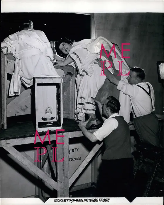 : Hattie Jacques on step ladder with prop men : Hattie Jacques on step ladder with prop men