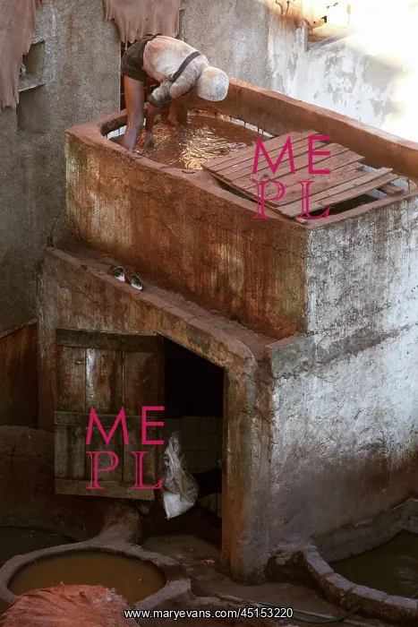 : Fez. High angle view of a tanner working in a pit constructed above a small : Fez. High angle view of a tanner working in a pit constructed above a small