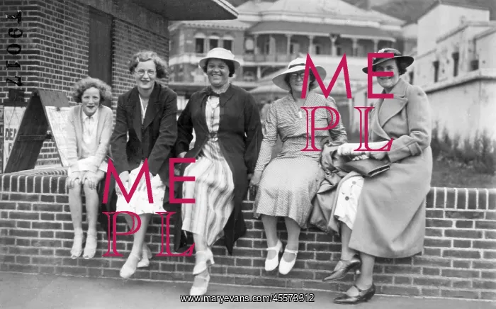 : Holiday group sitting on a wall in Margate, Kent : Holiday group sitting on a wall in Margate, Kent