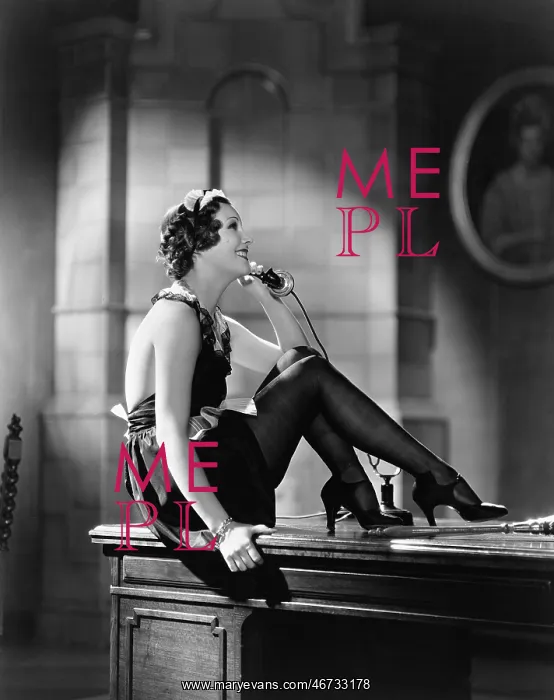 : Housekeeper sitting on a desk and talking on the telephone : Housekeeper sitting on a desk and talking on the telephone