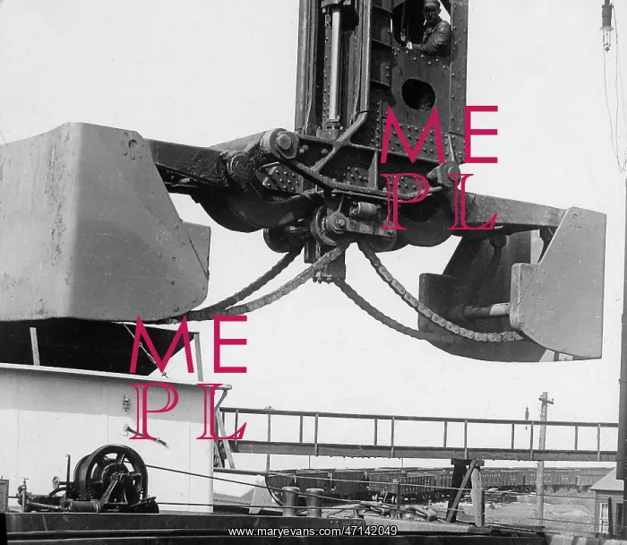 : A Hughlett clam-shell hoist unloading a ship's : A Hughlett clam-shell hoist unloading a ship's