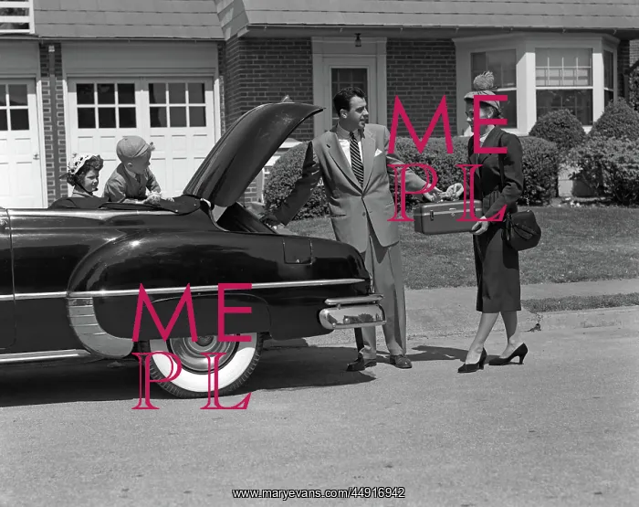 : Husband and wife packing trunk of convertible : Husband and wife packing trunk of convertible