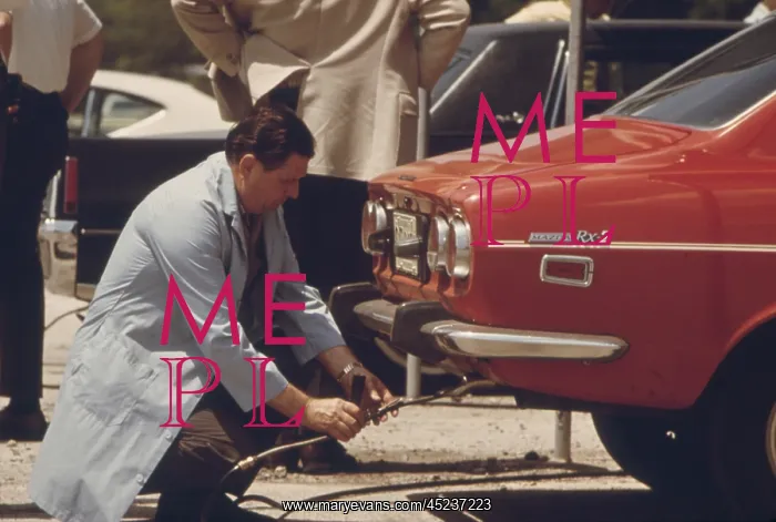 : An inspector testing the exhaust of an automobile ? : An inspector testing the exhaust of an automobile ?