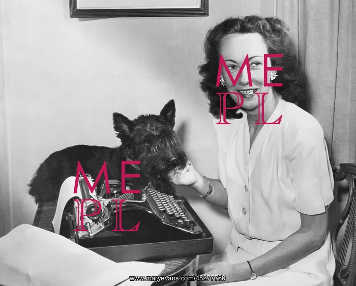 : Kay Summersby at her typewriter with her pet scottie : Kay Summersby at her typewriter with her pet scottie