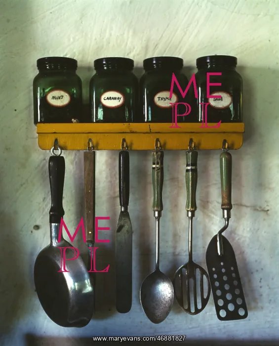 : Kitchen utensils hanging below a spice rack with mint, caraw : Kitchen utensils hanging below a spice rack with mint, caraw