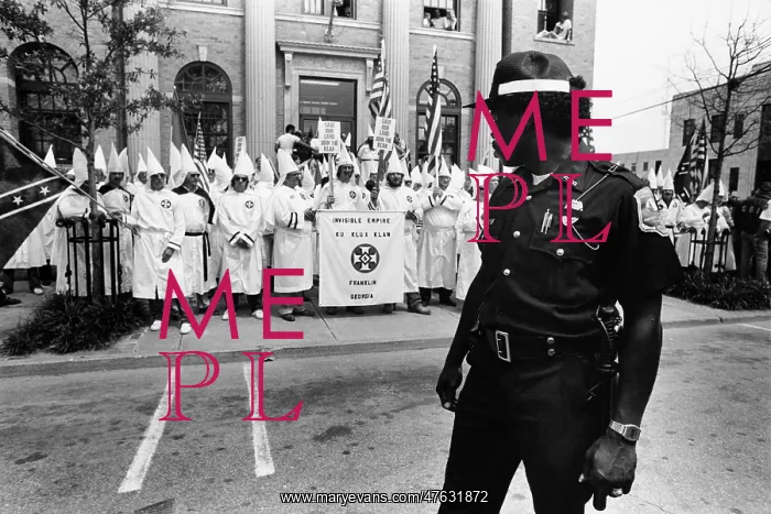 : KKK Rally. A policeman keeps an eye on a Ku Klux Klan rally at City Hall in La Grange : KKK Rally. A policeman keeps an eye on a Ku Klux Klan rally at City Hall in La Grange