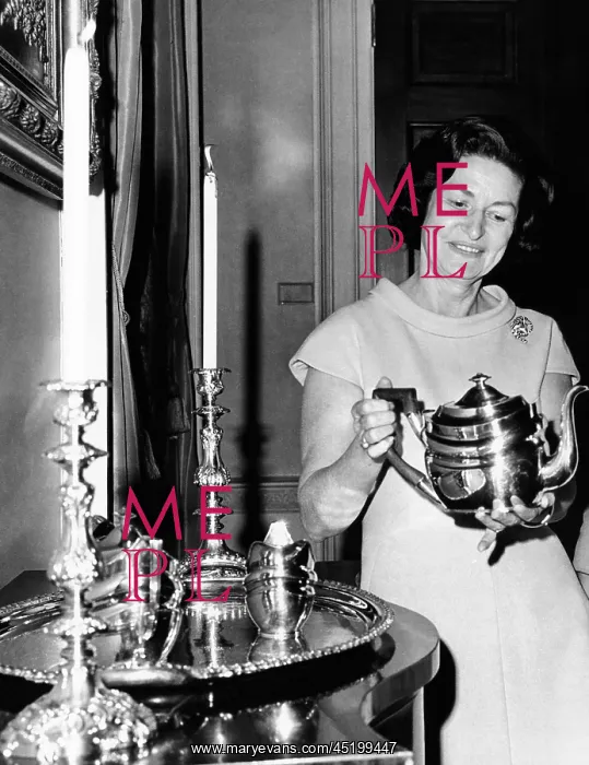 : Lady Bird Johnson holds a silver teapot ? : Lady Bird Johnson holds a silver teapot ?