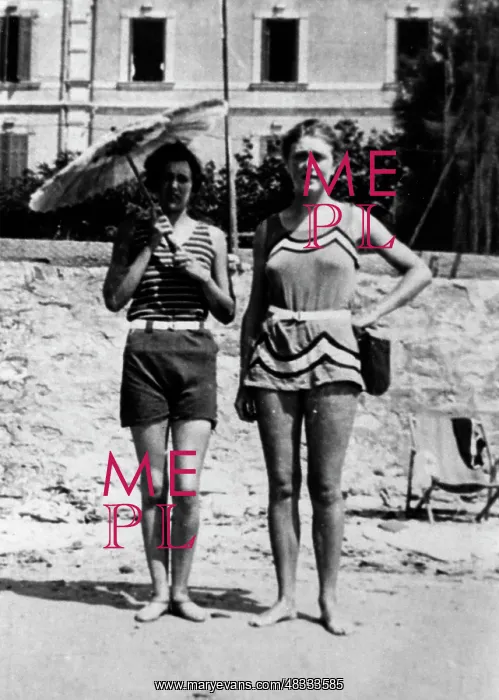 : Lady holding a sunshade with friend on the beach : Lady holding a sunshade with friend on the beach