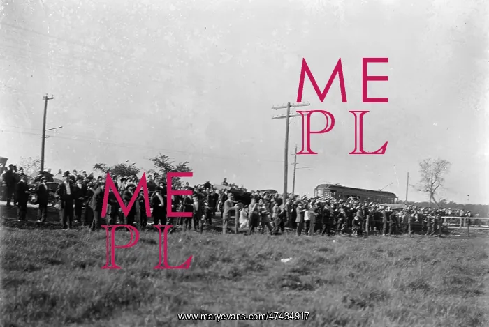 : Large crowd of spectators gathered at the edge of a field at : Large crowd of spectators gathered at the edge of a field at