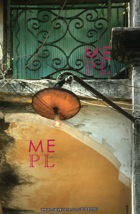 : Light bulb glows during the day from a rickety street lamp : Light bulb glows during the day from a rickety street lamp