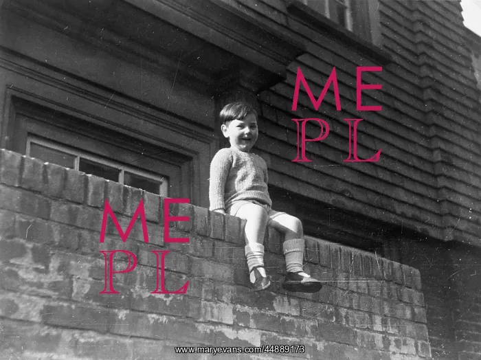 : Little boy sitting on a wall : Little boy sitting on a wall