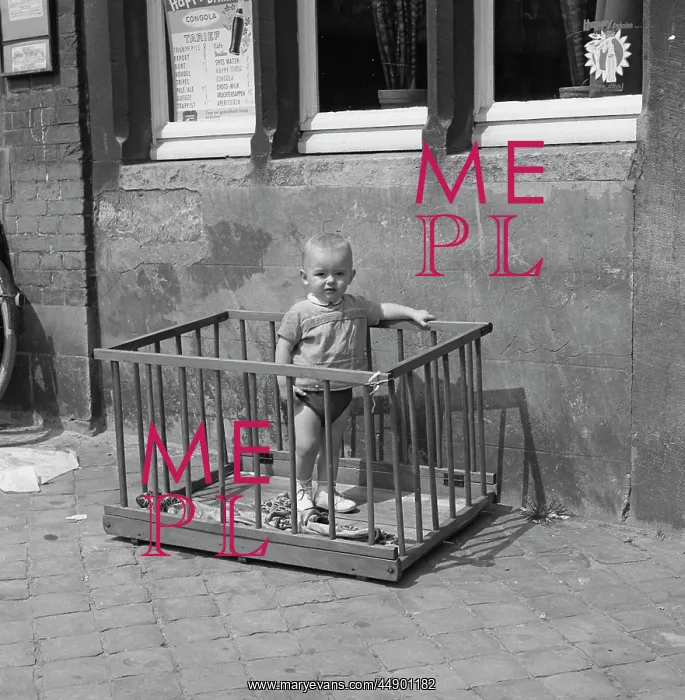 : Little boy standing in a playpen on a pavement : Little boy standing in a playpen on a pavement