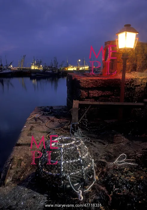 : Lobster pot lit by harbour light at night, Newlyn, Cornwall : Lobster pot lit by harbour light at night, Newlyn, Cornwall