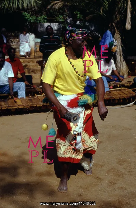 : Magenge, one of four rattle players, playing Njele : Magenge, one of four rattle players, playing Njele