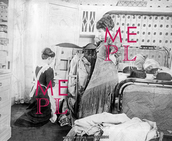 : Maid packing a suitcase, approx. 1910 : Maid packing a suitcase, approx. 1910