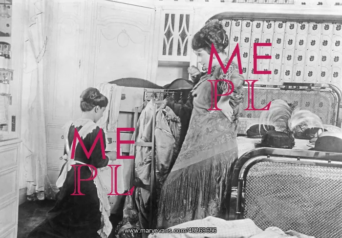 : A maid packs in the suitcase of a lady, 1913 : A maid packs in the suitcase of a lady, 1913
