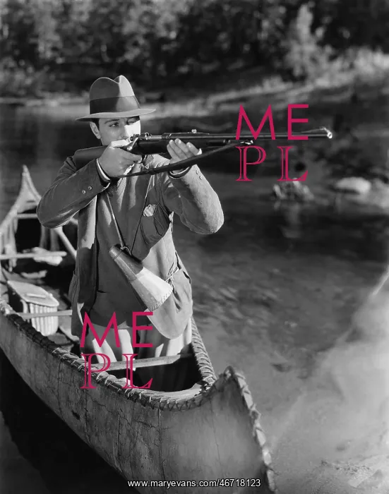 : Man aiming gun from canoe : Man aiming gun from canoe
