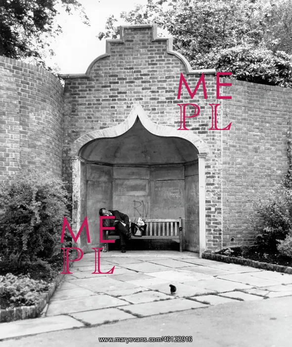 : Man asleep on a bench in an alcove in a park : Man asleep on a bench in an alcove in a park