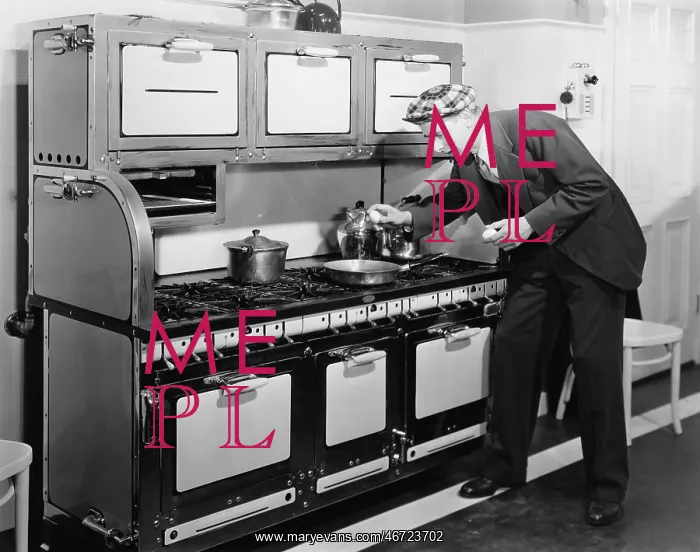 : Man breaking egg into a frying pan in the kitchen : Man breaking egg into a frying pan in the kitchen