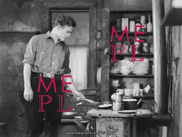 : Man cooking on woodstove : Man cooking on woodstove