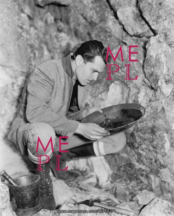 : Man crouching and panning for gold : Man crouching and panning for gold
